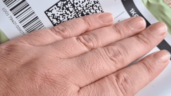 A hand flips over a green courier pack to show the Kat's Nip warning label.